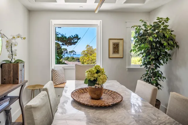 a dining room with furniture potted plants and a wooden floor