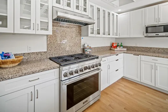 a kitchen with granite countertop cabinets stainless steel appliances and sink