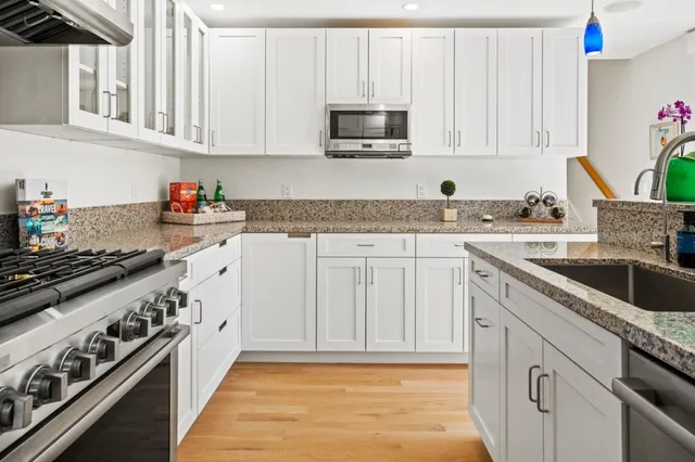 a kitchen with granite countertop a sink stove and cabinets