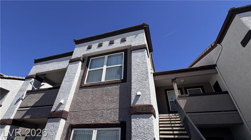 7255 West Sunset Road, Unit 2027 Las Vegas, NV 89113 - Photo 2 of 38 Multi-level stucco exterior showcasing modern architectural design against a clear blue sky.