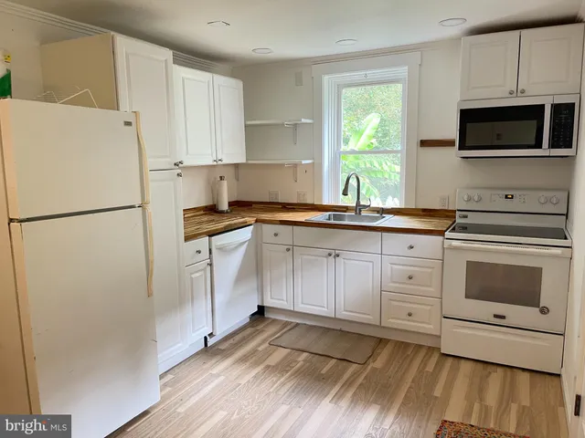 a kitchen with white cabinets and white appliances