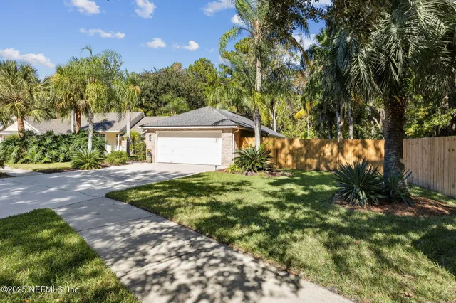 a backyard of a house with plants and large trees