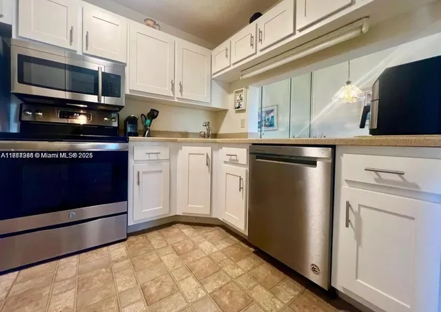 a kitchen with stainless steel appliances granite countertop a refrigerator stove and microwave