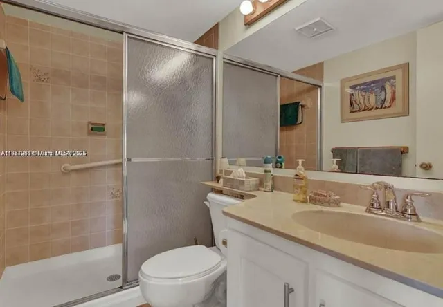 a bathroom with a granite countertop sink toilet and shower