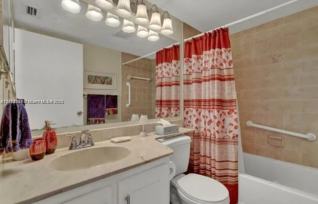 a bathroom with a sink vanity mirror and toilet