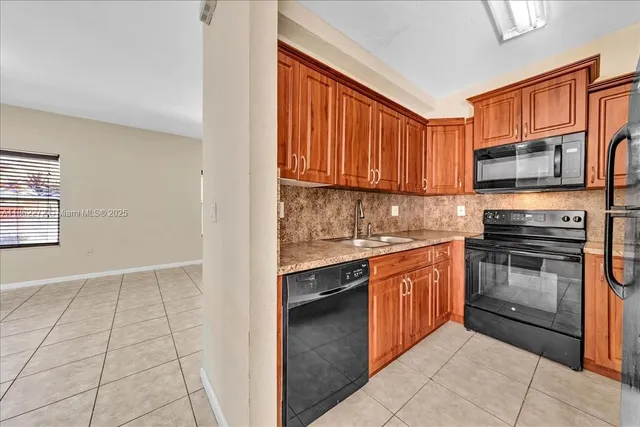 a kitchen with stainless steel appliances granite countertop a stove top oven a sink dishwasher and granite countertops