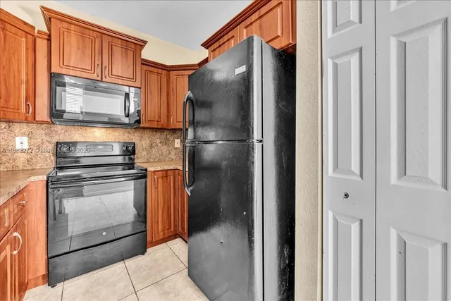 a kitchen with stainless steel appliances granite countertop a refrigerator stove and cabinets