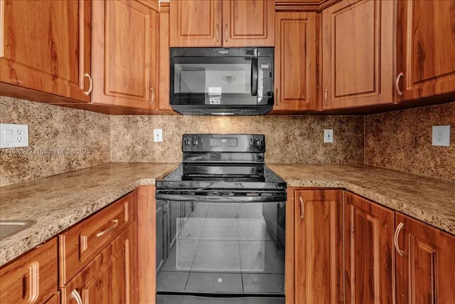 a kitchen with stainless steel appliances granite countertop a stove top oven microwave and cabinets