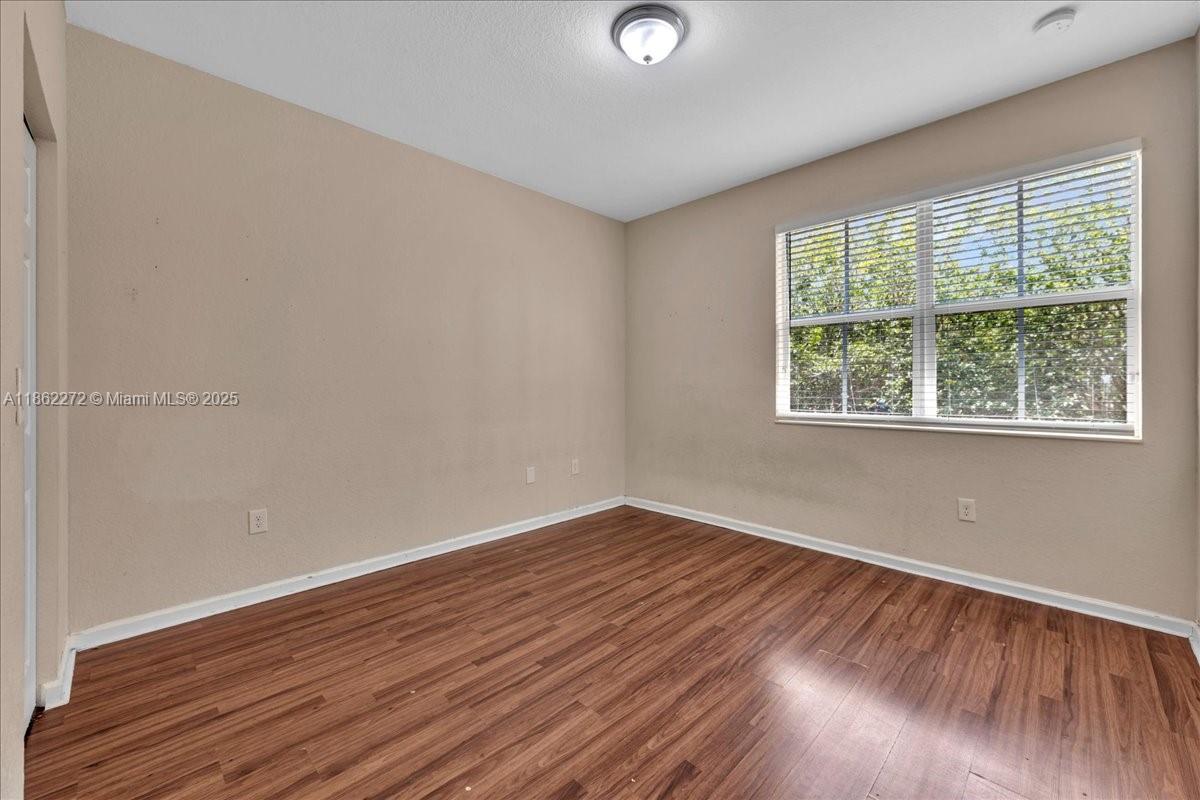 12252 Southwest 25th Court, Unit 1614 Miramar, FL 33025 - Photo 24 of 46 an empty room with wooden floor and windows
