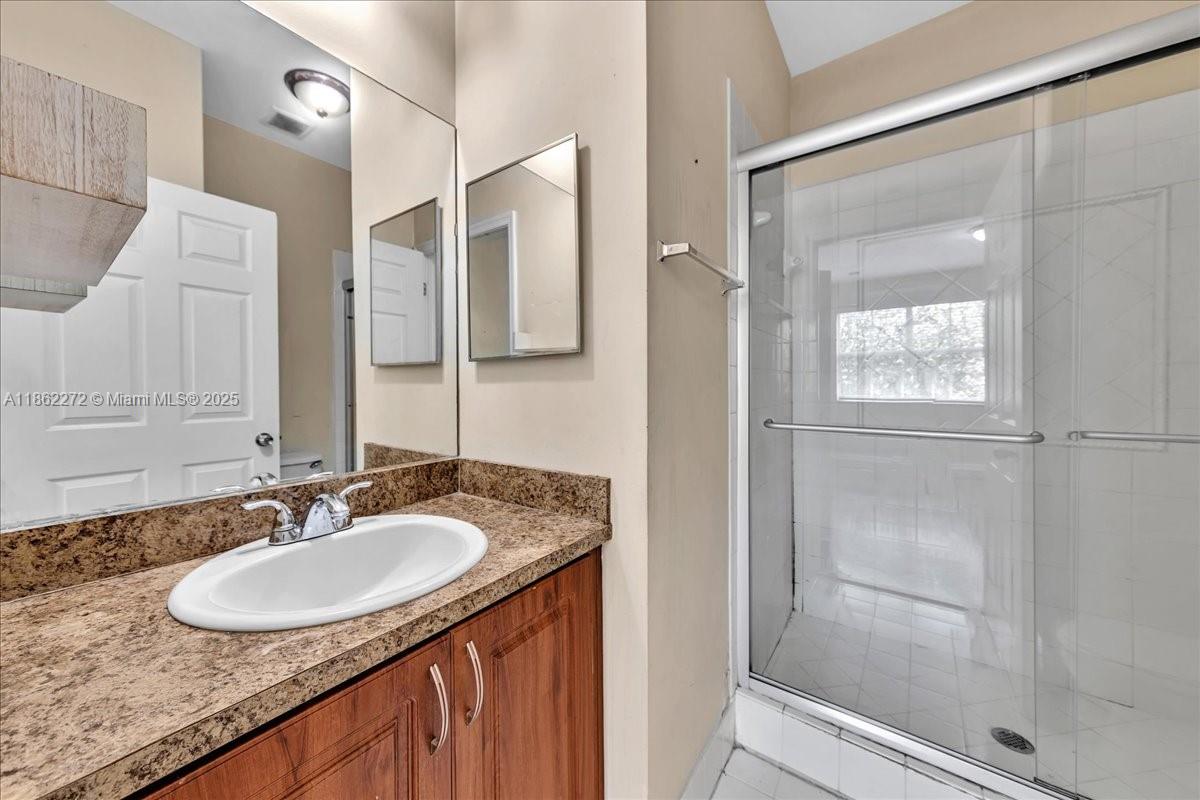 12252 Southwest 25th Court, Unit 1614 Miramar, FL 33025 - Photo 29 of 46 a bathroom with a granite countertop sink and a mirror