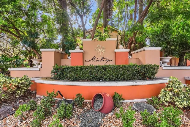 an aerial view of a house with swimming pool and large trees