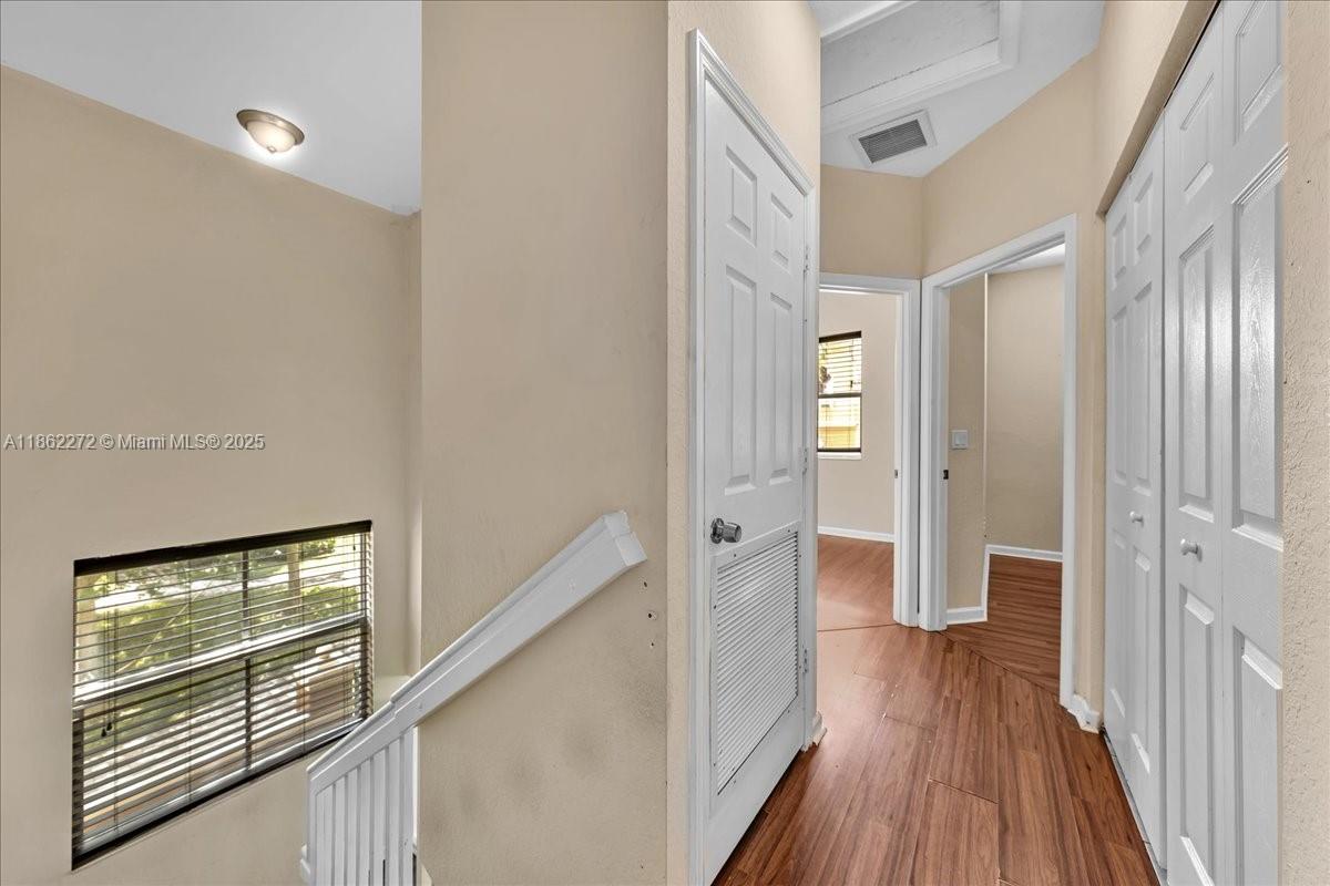 12252 Southwest 25th Court, Unit 1614 Miramar, FL 33025 - Photo 31 of 46 a view of a hallway with wooden floor and staircase