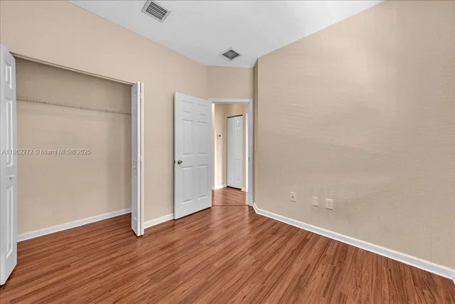 a view of a room with wooden floor and windows