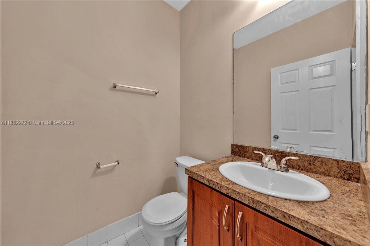 12252 Southwest 25th Court, Unit 1614 Miramar, FL 33025 - Photo 40 of 46 a bathroom with a granite countertop sink a mirror and a toilet