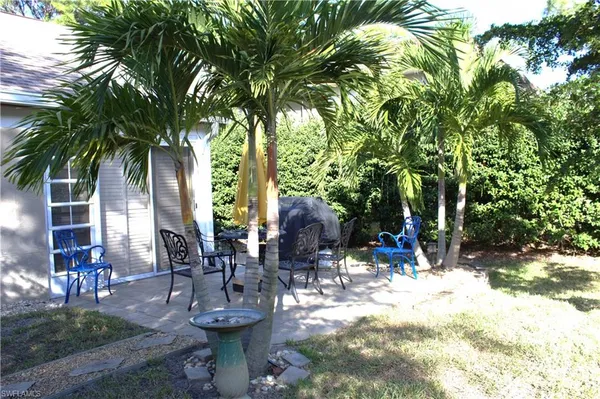 a view of a patio with chairs and potted plants