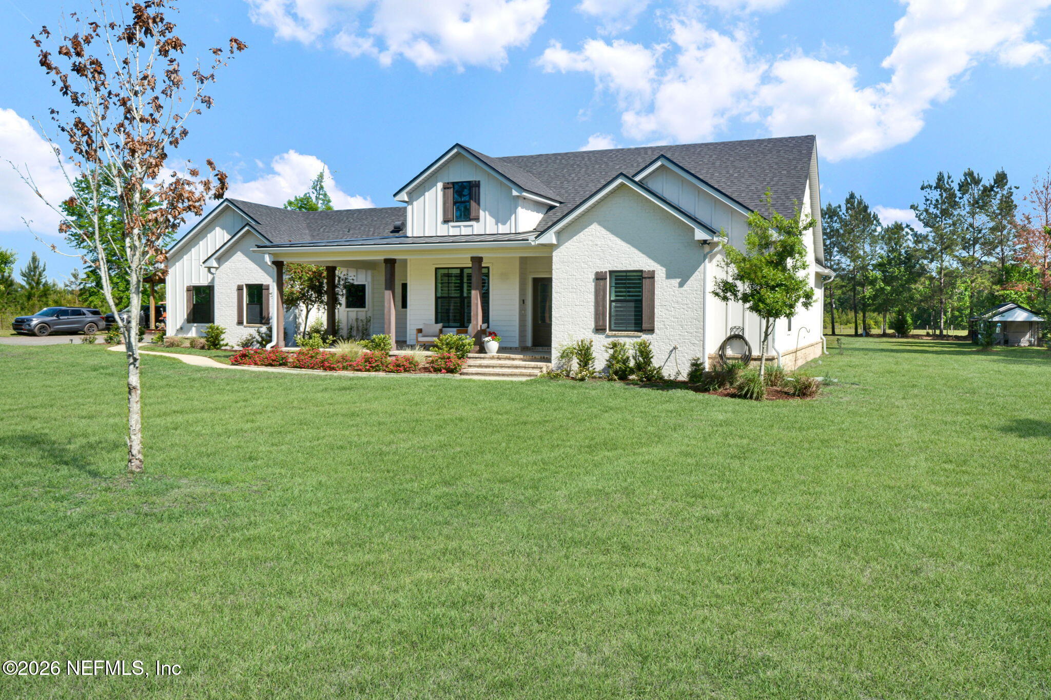 57353 Sandy Oaks Lane Callahan, FL 32011 - Photo 3 of 61 a front view of a house with a garden and trees