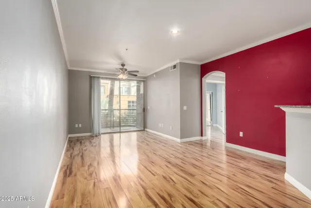 a view of an empty room with window and wooden floor