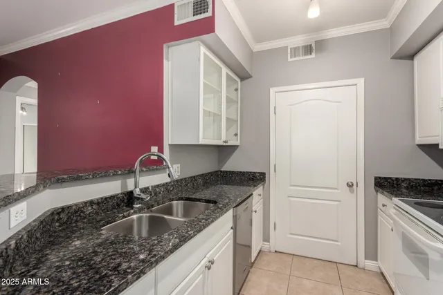 a kitchen with granite countertop a sink stove and cabinets