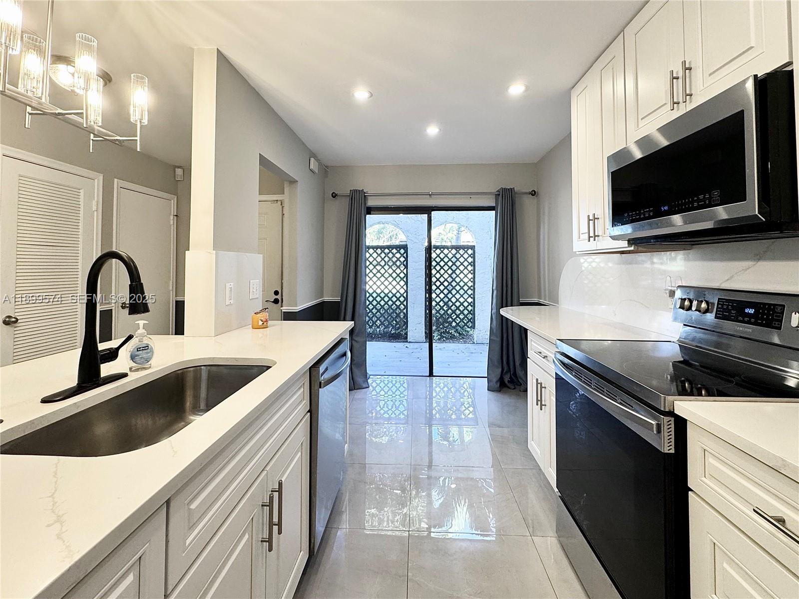 a kitchen with a sink and a stove top oven with wooden floor