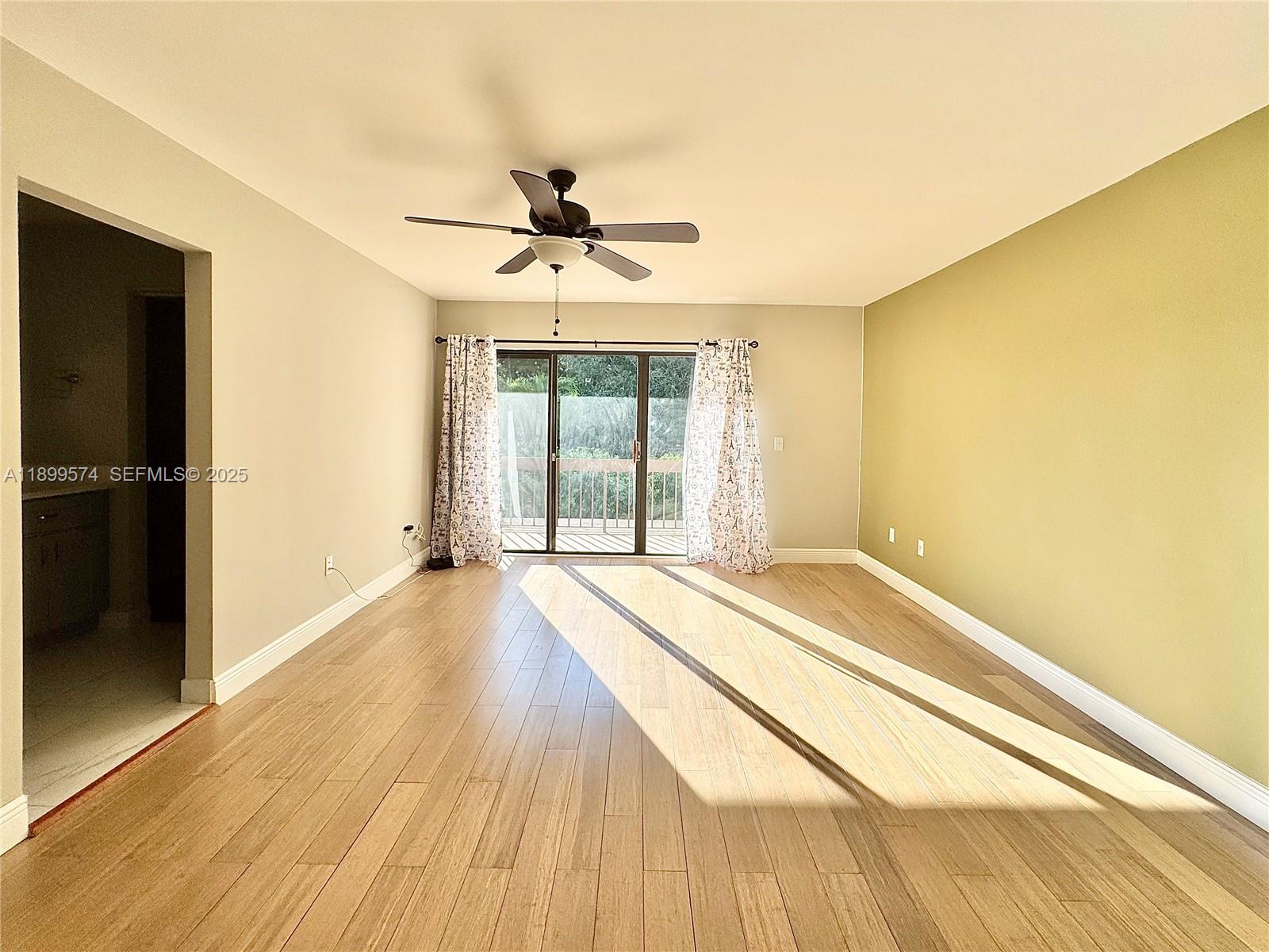 21643 Cypress Road, Unit 14D Boca Raton, FL 33433 - Photo 12 of 26 a view of an empty room with wooden floor and a window