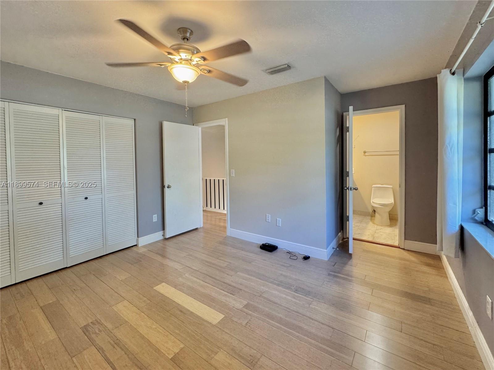 21643 Cypress Road, Unit 14D Boca Raton, FL 33433 - Photo 19 of 26 a view of an empty room with wooden floor and a ceiling fan
