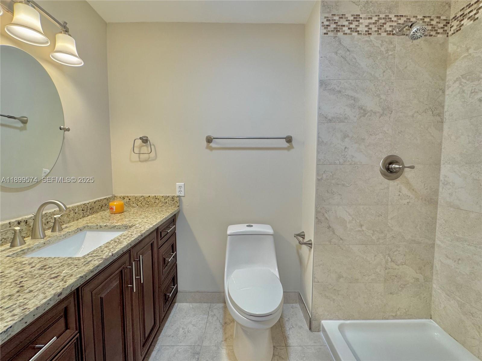 21643 Cypress Road, Unit 14D Boca Raton, FL 33433 - Photo 21 of 26 a bathroom with a granite countertop sink toilet and shower