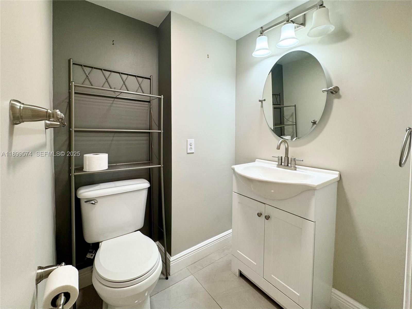 21643 Cypress Road, Unit 14D Boca Raton, FL 33433 - Photo 5 of 26 a bathroom with a toilet sink and mirror