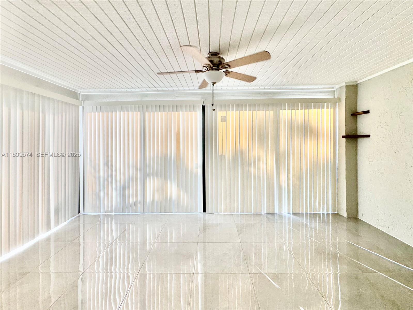 21643 Cypress Road, Unit 14D Boca Raton, FL 33433 - Photo 9 of 26 a view of a livingroom with a ceiling fan and window