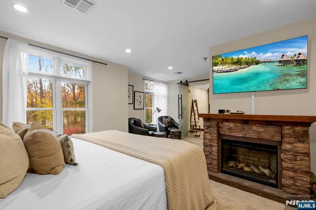 a bed room with a bed a fireplace and a television