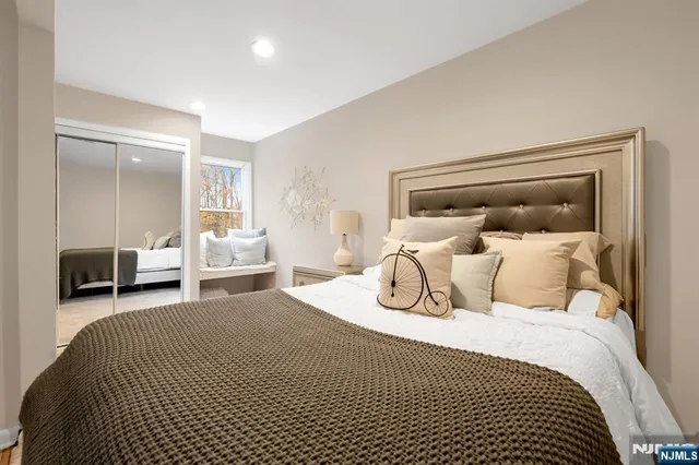 a bedroom with a bed and a large mirror