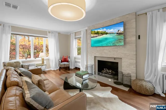 a living room with furniture a flat screen tv and a fireplace