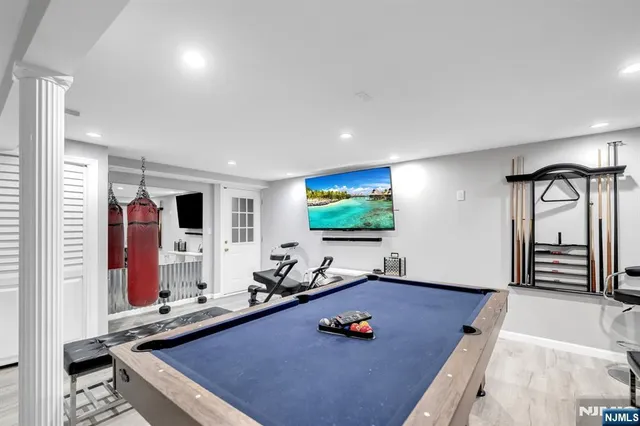 a room with furniture pool table flat screen tv and windows