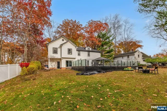 a front view of a house with a yard tree and outdoor seating