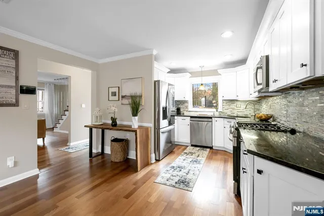 a kitchen with a sink cabinets stainless steel appliances and view living room