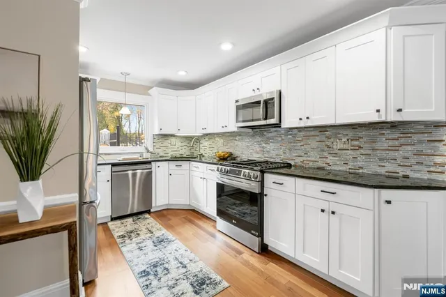 a kitchen with granite countertop white cabinets and white appliances