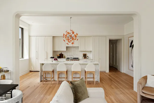a large kitchen with granite countertop a stove and white cabinets