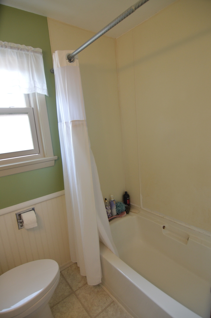 414 Brown Street Wauconda, IL 60084 - Photo 21 of 29 a bathroom with a bathtub a window and a shower