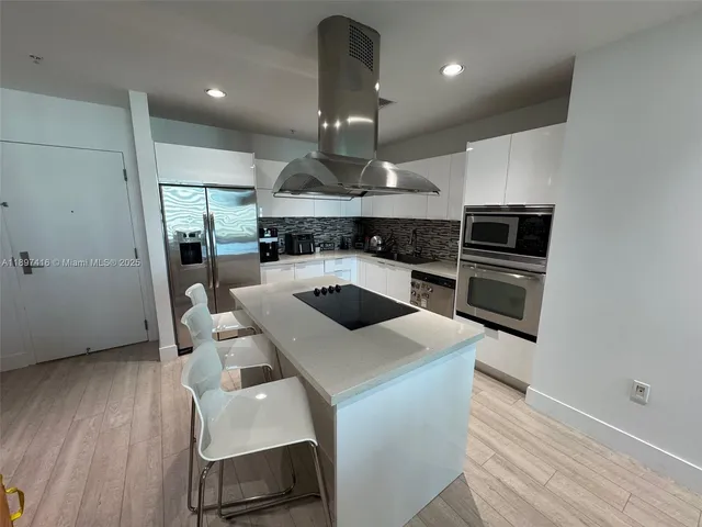 a kitchen with a table chairs refrigerator and microwave