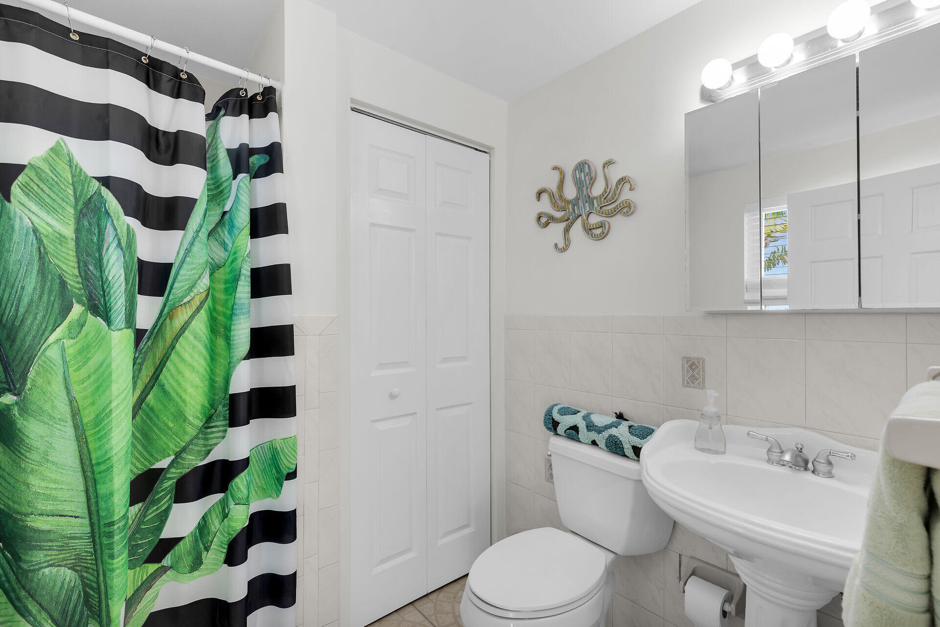 351 5th Street Key Colony Beach, FL 33051 - Photo 32 of 43 a white toilet sitting next to a bathroom sink and a potted plant