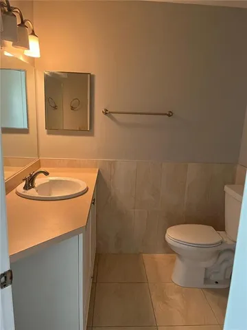 a bathroom with a sink a toilet and mirror