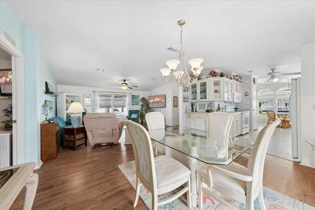 a view of a dining room and livingroom with furniture wooden floor a chandelier