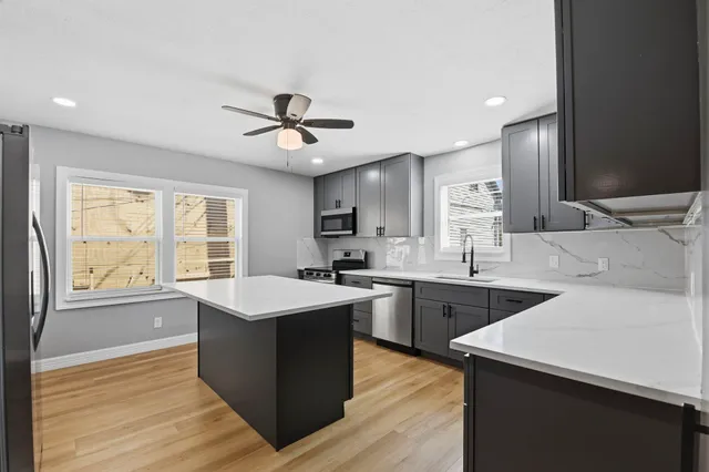 a kitchen with stainless steel appliances granite countertop a sink stove and refrigerator