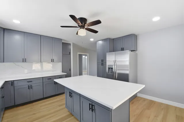 a kitchen with kitchen island a sink stainless steel appliances and cabinets