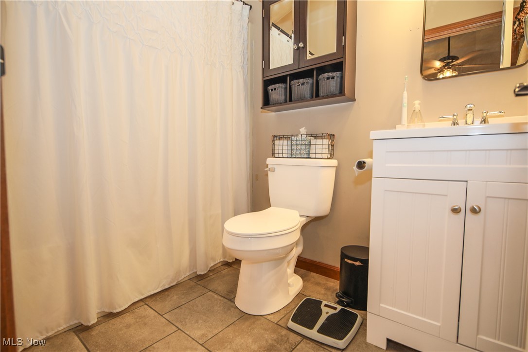 64640 Patterson Hill Road Bellaire, OH 43906 - Photo 10 of 16 Bathroom featuring vanity, a ceiling fan, baseboards, tile patterned flooring, and toilet