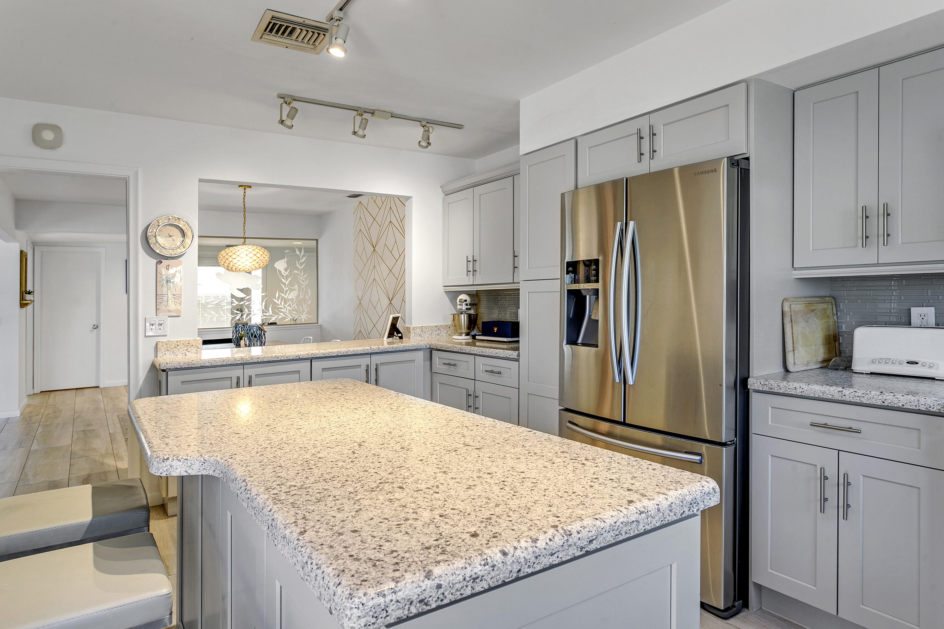 3697 Cape Pointe Circle Jupiter, FL 33477 - Photo 18 of 55 a kitchen with kitchen island sink refrigerator and microwave