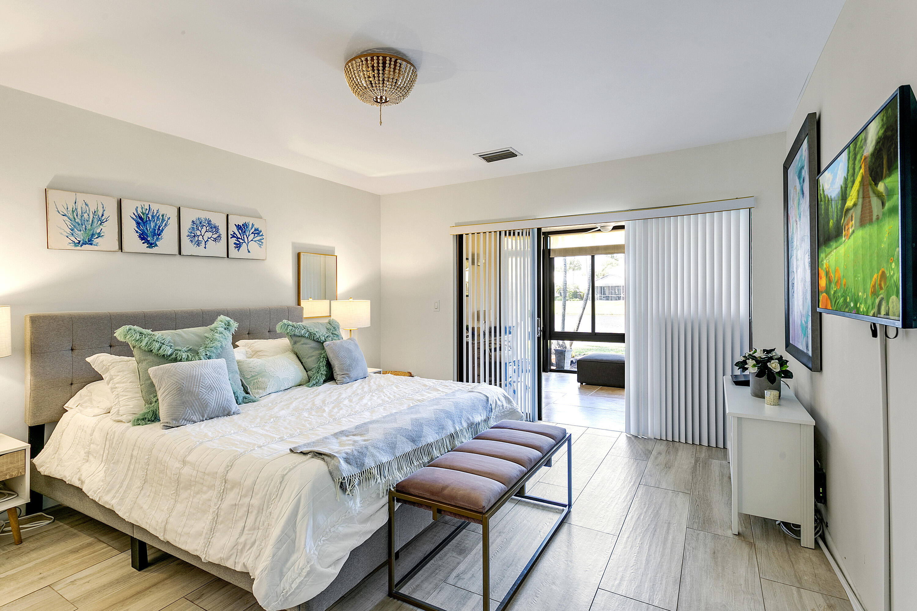 3697 Cape Pointe Circle Jupiter, FL 33477 - Photo 21 of 55 a bedroom with a large bed a flat tv screen and a couch