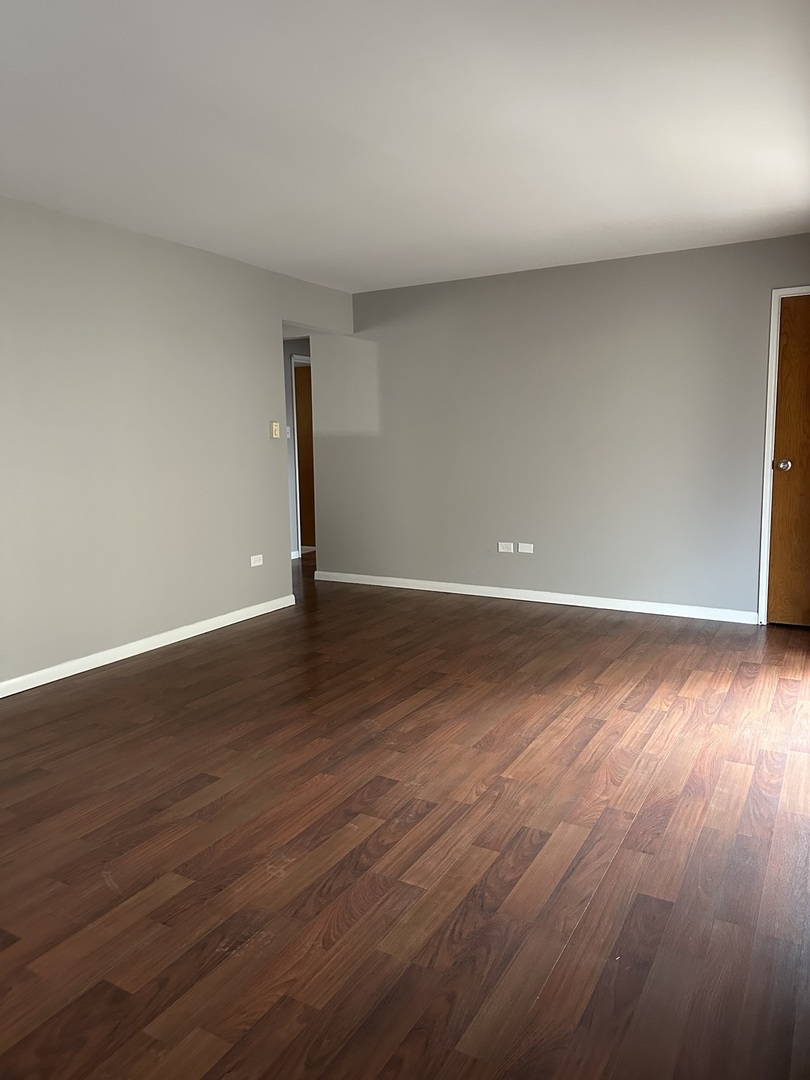 6334 West 65th Street, Unit 2N Chicago, IL 60638 - Photo 2 of 9 a view of an empty room with wooden floor and a window