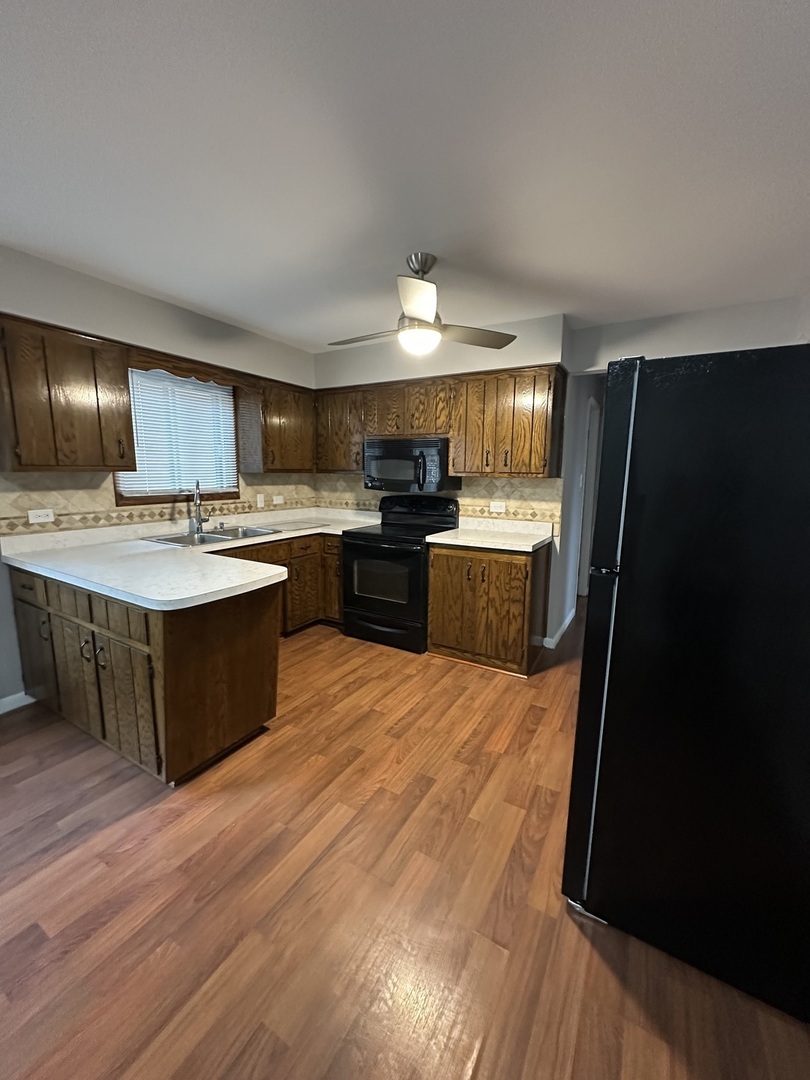 6334 West 65th Street, Unit 2N Chicago, IL 60638 - Photo 4 of 9 a kitchen with kitchen island granite countertop wooden floors stainless steel appliances a sink and cabinets
