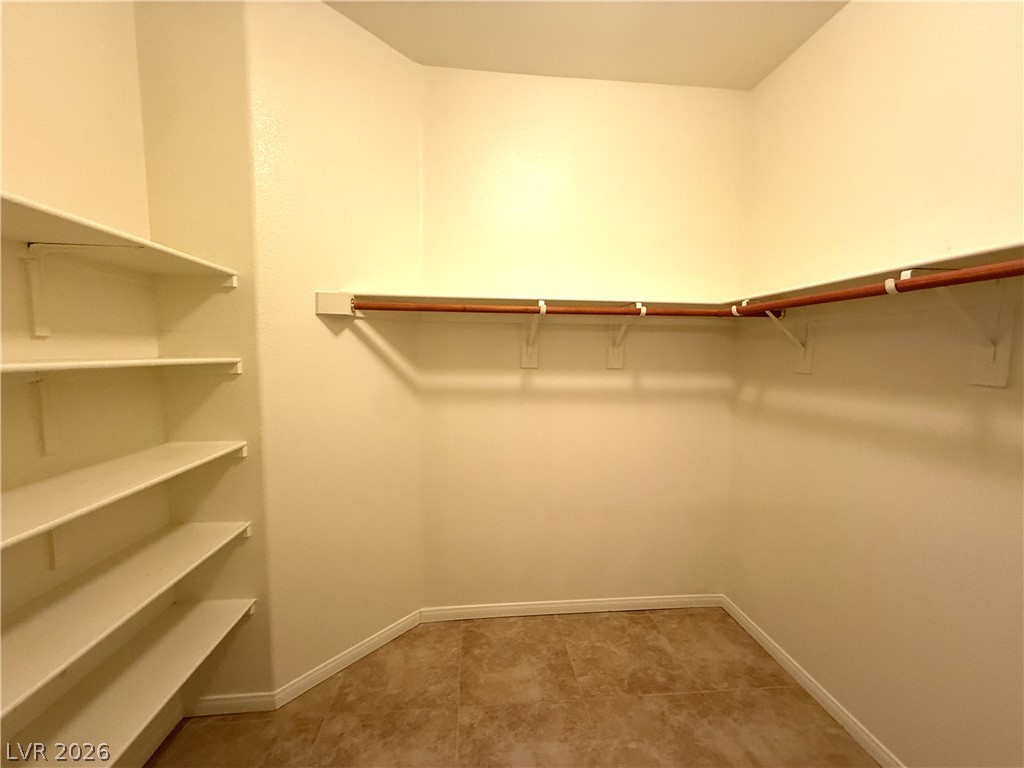 5942 Rampolla Drive Las Vegas, NV 89141 - Photo 15 of 27 Ample shelving and hanging space defines this organized primary walk-in closet.