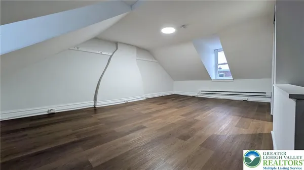 an empty room with wooden floor and door